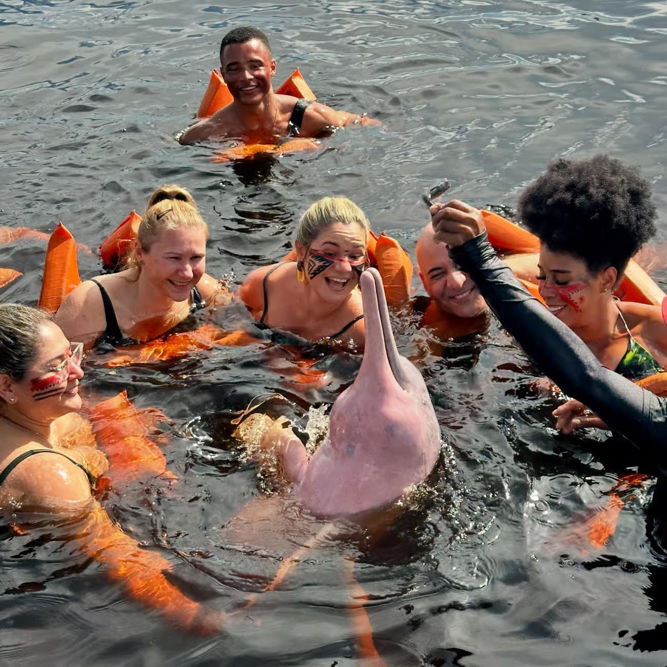 Turistas nadando com boto-cor-de-rosa no rio Negro
